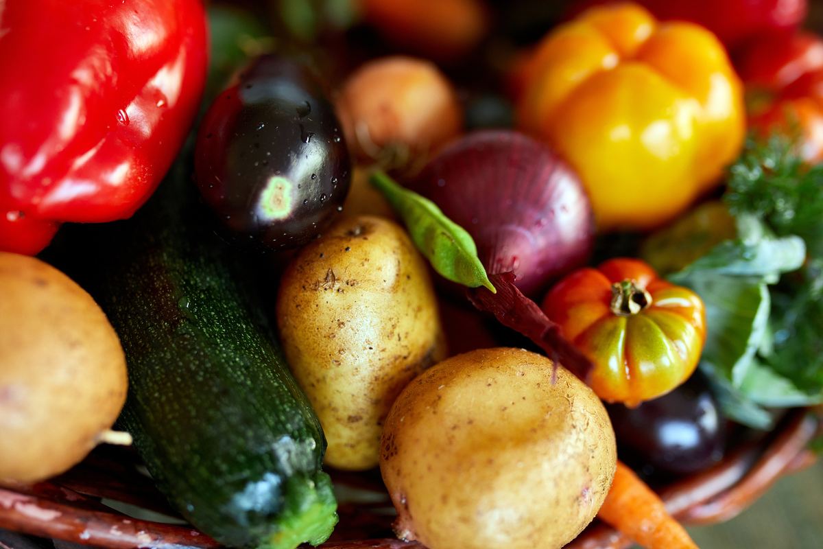 Freshly harvested vegetables including peppers, potatoes and onions